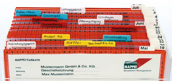 MAPPEI Wiedervorlage: Transparente Ordnungsbox mit roten Leitkarten und farbigen, beschrifteten Reitern zur tagesgenauen Organisation von Aufgaben und Terminen im Büro.