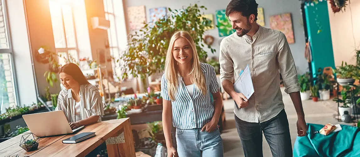 Eine Frau und ein Mann unterhalten sich während des Laufens in einem modernen Büro