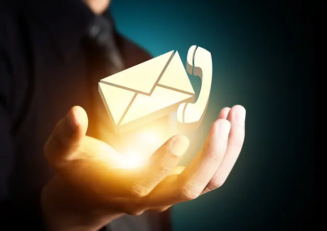 Symbolische Darstellung: Eine geöffnete Hand hält leuchtende Icons für einen Briefumschlag (E-Mail) und ein Telefonsymbol, die für Kontakt und Kommunikation stehen.