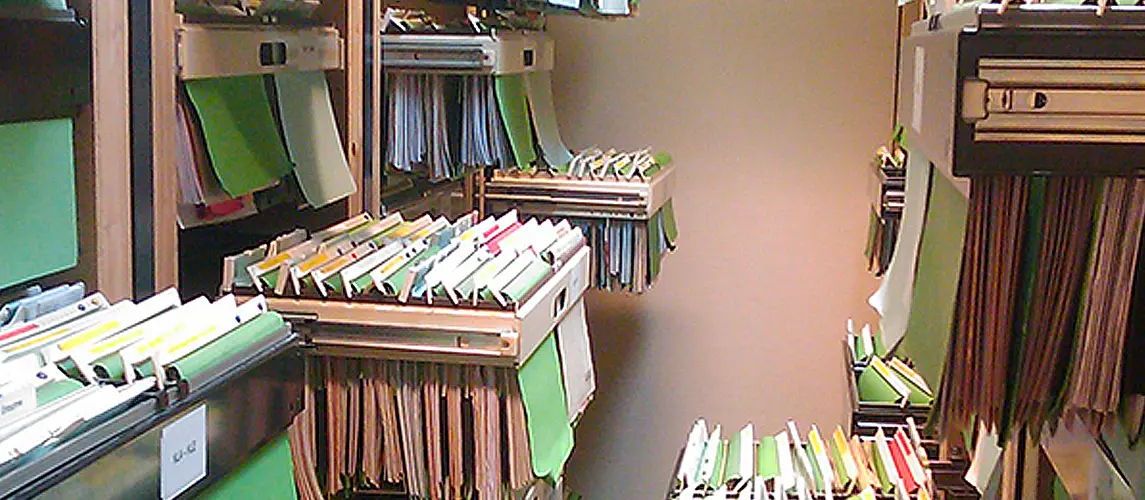 Hängeregister Detailaufnahme eines Hängeregistraturschranks in einem Archiv, gefüllt mit grünen Hängemappen und farbigen Reitern zur systematischen Organisation von Dokumenten.