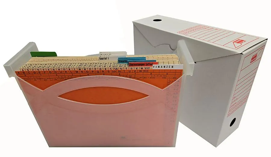 Ordnungsbox gefüllt mit orangefarbener Leitkarte, dahinter mehrere Ordnungsmappen mit angeklebten Selbstklebereitern, rechts daneben befindet sich eine weiße Archivschachtel mit rotem Aufdruck