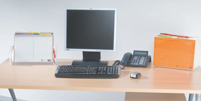 Arbeitsplatz mit Mappei Ein aufgeräumter Schreibtisch mit einem Laptop, einem Kalender und einem transparenten MAPPEI Ablagesystem, das eine effiziente und übersichtliche Arbeitsplatzorganisation ermöglicht.